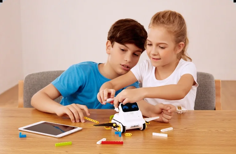 Dos niños juegan con Codey Rocky y piezas de construcción; imagen de Makeblock.
